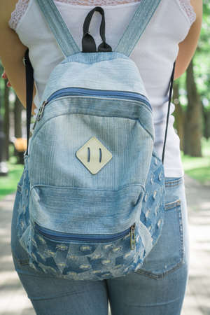 Rear view of hipster girl carring backpack on her back