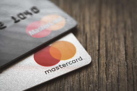MINSK, BELARUS - July 31, 2019. Mastercard logos on credit cards, wooden table backgroundのeditorial素材