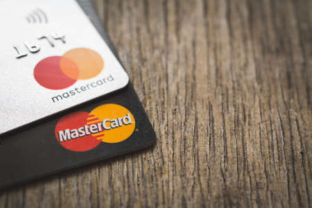 MINSK, BELARUS - July 31, 2019. Mastercard logos on credit cards, wooden table backgroundのeditorial素材