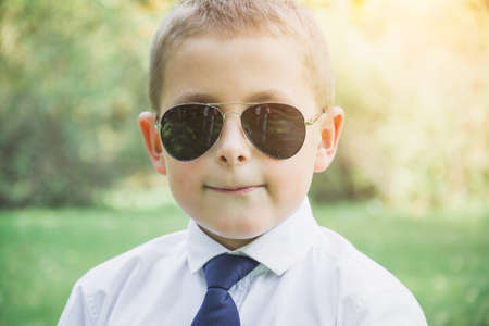 Outdoor Portrait of a handsome eight year old boy in sunglassesの写真素材