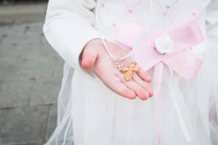 Two small Orthodox crosses in the hands of a small child after the baptismal rite in the church
