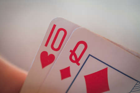 Ten and queen, Playing cards in hand on the table, poker nands, game conceptの写真素材