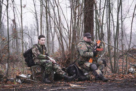 Two Russian soldiers in the forest take a break from a long cross-country trek, war military conceptの写真素材