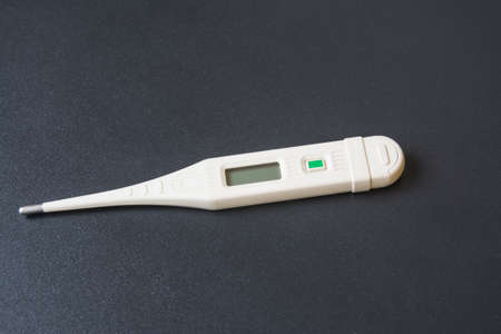 electronic thermometer on a black background close-up