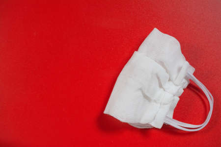 handmade face mask to protect against coronavirus COVID-19 on a red backgroundの写真素材