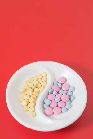 prescription painkiller antidepressants in a plate on a red backgroundの写真素材