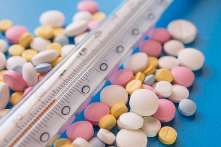 thermometer and pills close up horizontal shot