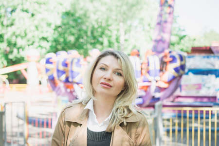 beautiful stylish blonde woman on a footpath in the park portraitの写真素材