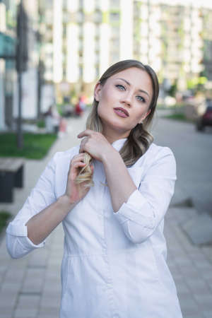 Young girl nurse on a city street portraitの写真素材