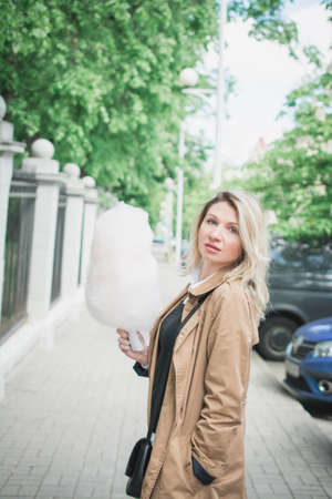 Close up portrait of a smiling girl holding cotton candy outdoor