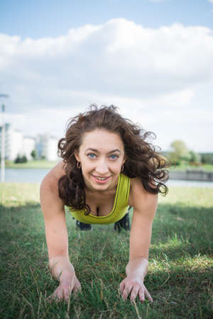 Sport woman doing lawn exercises and stretching on the grass out