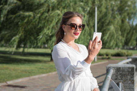 Girl and cell phone close-up shot on a summer dayの写真素材