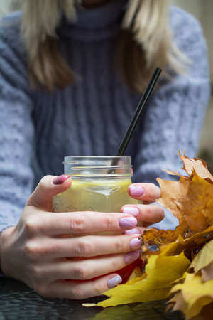 Closeup of female hands with a herbal tea mug of beverageの写真素材