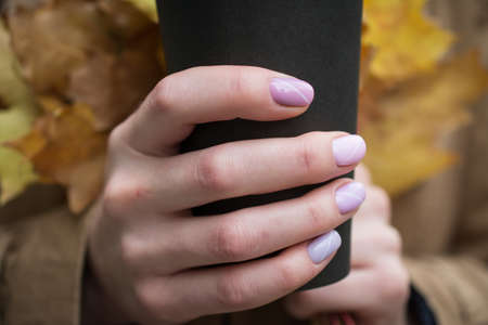 Big cup of coffee and female hands with beautiful nails