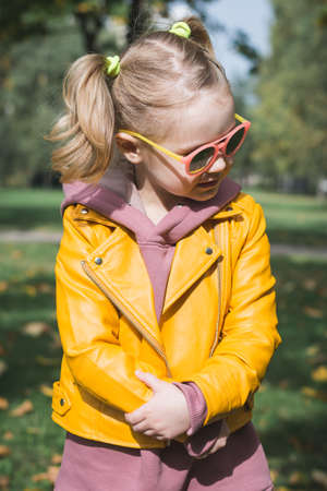 Portrait of a little three year old girl in an autumn park