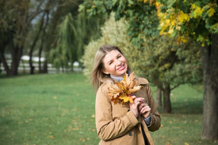 Portrait of beautiful blonde woman in autumn park