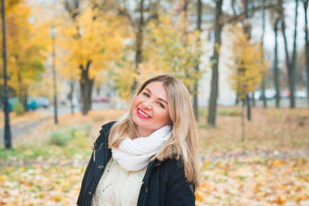 Cute girl in an autumn park on a background of yellow foliage