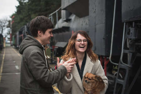 A guy and a girl are walking together among old steam locomotives, love conceptの写真素材
