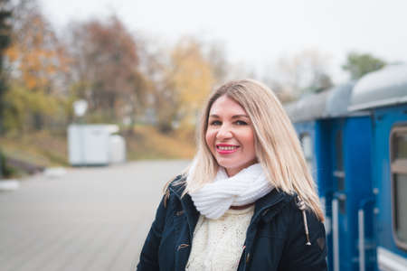 A beautiful girl is photographed in the autumn on the street of her cityの写真素材
