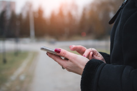 Woman Hands Texting On A Smart Phone With Urban Background close upの写真素材