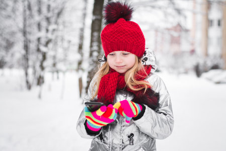Happy Baby Girl portrait In red Hat Outdoor Winter Background