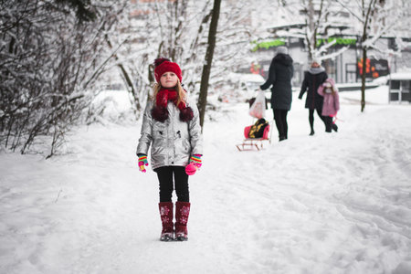 Little happy girl having fun in winter in a snowy forestの写真素材