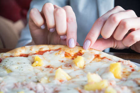 Female hand take slice of pizza inside