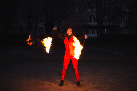 A girl shows a fire show in the night