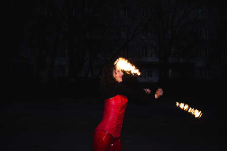 A girl shows a fire show in the nightの写真素材