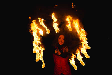 A girl shows a fire show in the nightの写真素材