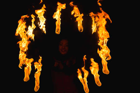 A girl shows a fire show in the night