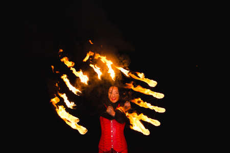A girl shows a fire show in the night