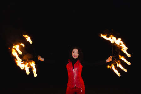 A girl shows a fire show in the night