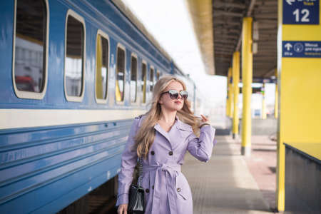 Stylish Beautiful russian girl blonde with a phone at the railway stationの写真素材