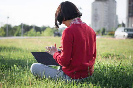 Beautiful girl portrait in summer on the lawnの写真素材