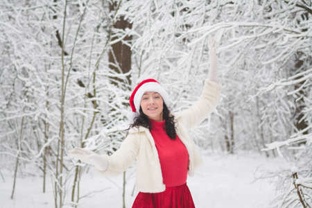Beautiful girl in a snowy forest in Christmas clothesの写真素材