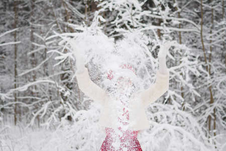 Beautiful girl in a snowy forest in Christmas clothesの写真素材