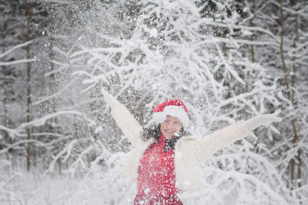 Beautiful girl in a snowy forest in Christmas clothesの写真素材
