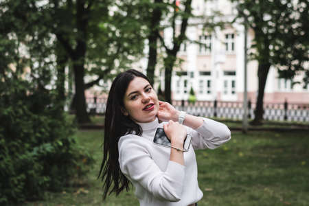Stylish beautiful brunette girl in a summer city park