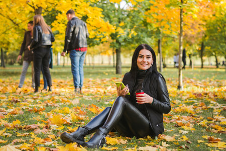 Beautiful glamorous girl portrait in autumn parkの写真素材