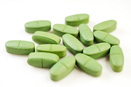 Green pain pills isolated on a white backgroundの写真素材