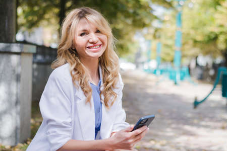 Business lady with a phone in her hands on the streetの写真素材