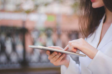 Urban happy business woman using tablet computer and working outsideの写真素材