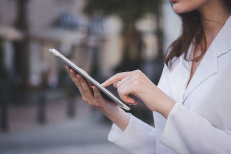 Portrait of caucasian businesswoman using tablet pc outside