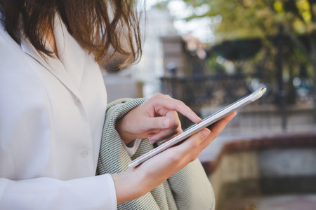 Business cauasian woman hand with digital device going down city street