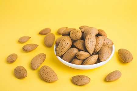 almonds in a plate on a yellow background
