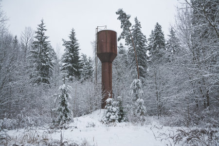 Abandoned water tower in the snowy forestの写真素材