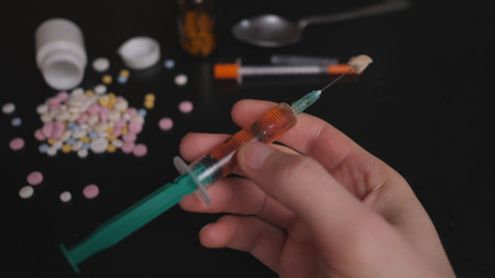 addicts table pills and injection on the black tableの写真素材
