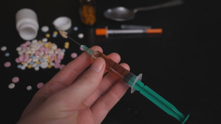 addicts table pills and injection on the black tableの写真素材