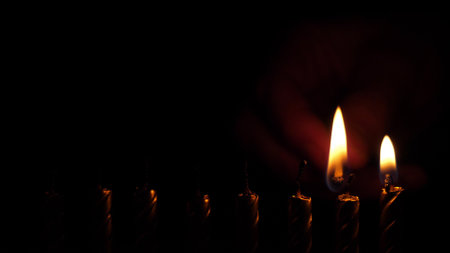 old holiday candles burn against a black backgroundの写真素材